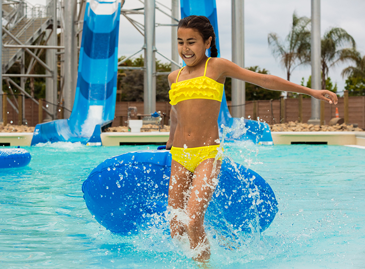 Girl pulls inner tube in front of water slide Girl pulls inner tube in front of water slide